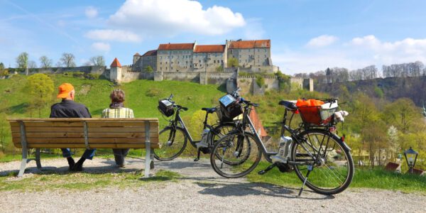 Seniorenpaar bei einem Fahrradausflug mit Burgpanorama © Burghauser Touristik GmbH