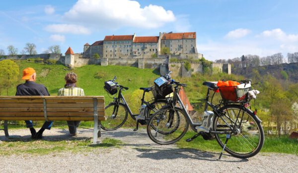 Seniorenpaar bei einem Fahrradausflug mit Burgpanorama © Burghauser Touristik GmbH