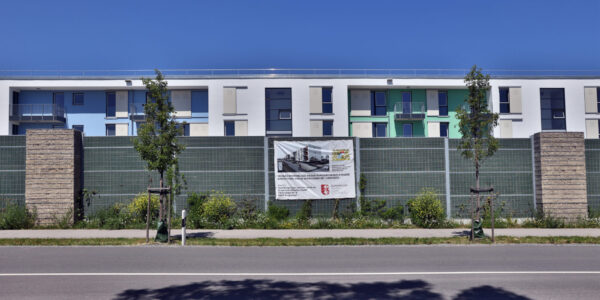 Wohnblock in Burghausen mit Banner der BuWoG am Zaun © Gerhard Nixdorf