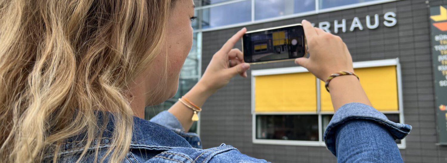 Frau beim Fotografieren des Bürgerhauses © Alexandra Könisgeder