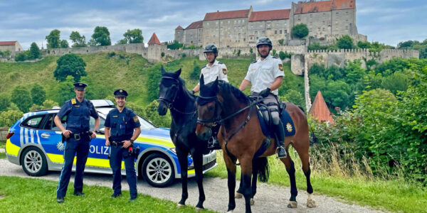 Zwei berittene Polizisten und zwei Polizisten mit Streifenwagen mit Bugpanorama © Stadt Burghausen