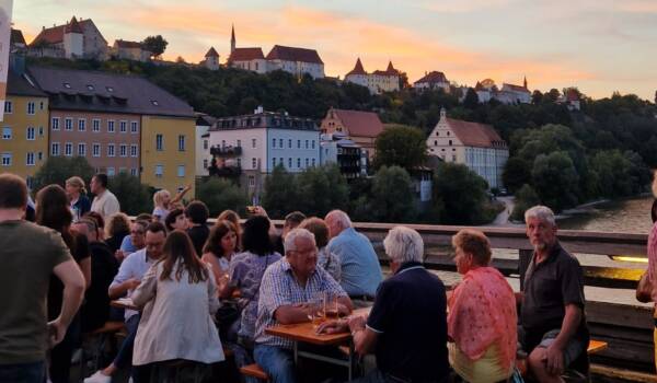 Besucherinnen und Besucher auf Bierbänken auf der Salzachbrücke © Hannah Eberle