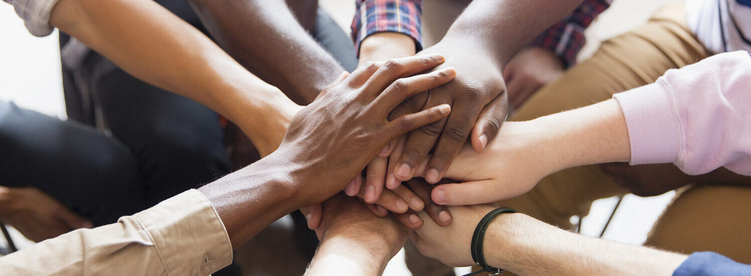 Mehrere Personen halten Hände in der Mitte © Westend61 / Caiaimage / Tom Merton