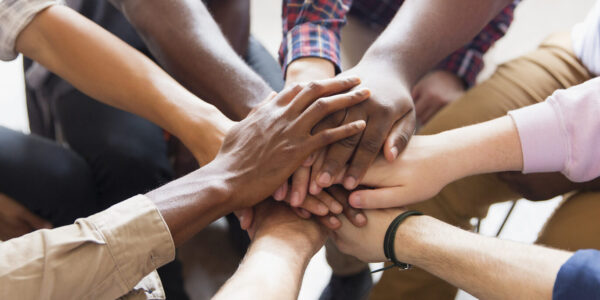 Mehrere Personen halten Hände in der Mitte © Westend61 / Caiaimage / Tom Merton