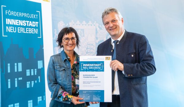 Sigrid Resch, GF der Burghauser Touristik, nahm den Förderbescheid „Innenstadt neu erleben!“ für die Nacht der Straßenkünstler von Staatssekretär Roland Weigert entgegen.