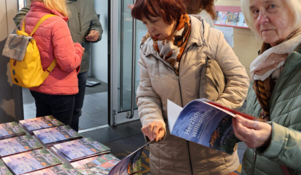 Besucherinnen des Neubürgerfests blättern durch die Neubürgerbroschüre © Gerhard Nixdorf