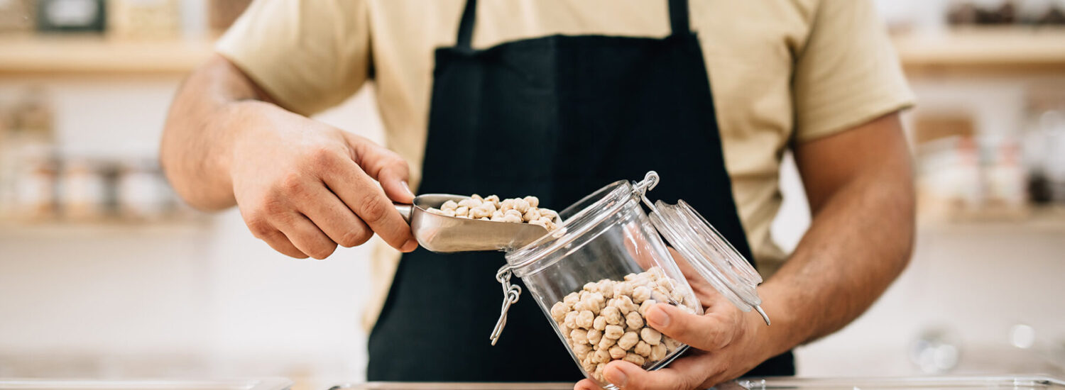 Verkäufer füllt Kichererbsen in ein Glas © Westend61 / Addictive Stock / Alex Salcedo