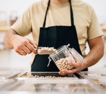 Verkäufer füllt Kichererbsen in ein Glas © Westend61 / Addictive Stock / Alex Salcedo