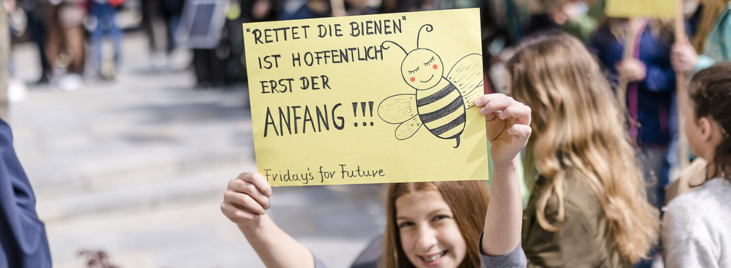 Ein Mädchen hält eine Schild auf einer Demo hoch © Westend61 / Stefanie Baum