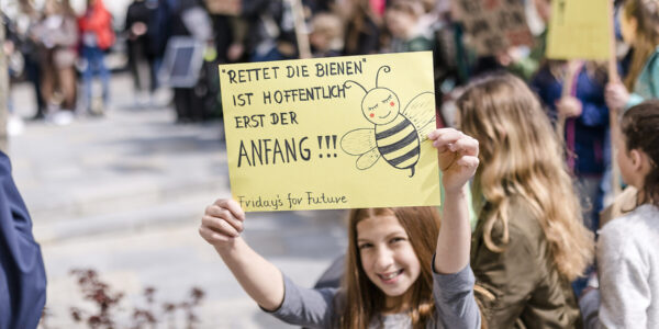 Ein Mädchen hält eine Schild auf einer Demo hoch © Westend61 / Stefanie Baum