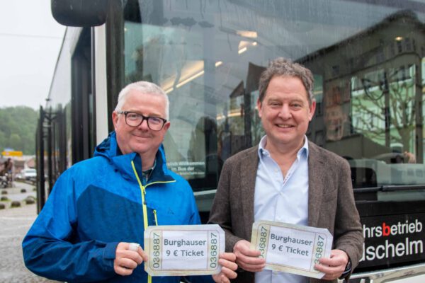 Erster Bürgermeister Florian Schneider (l.) und Martin Hinterwinkler, Leiter des Ordnungsamts in Burghausen, mit symbolischen 9-Euro-Tickets am Stadtplatz. Fotocredit: Stadt Burghausen/ebh