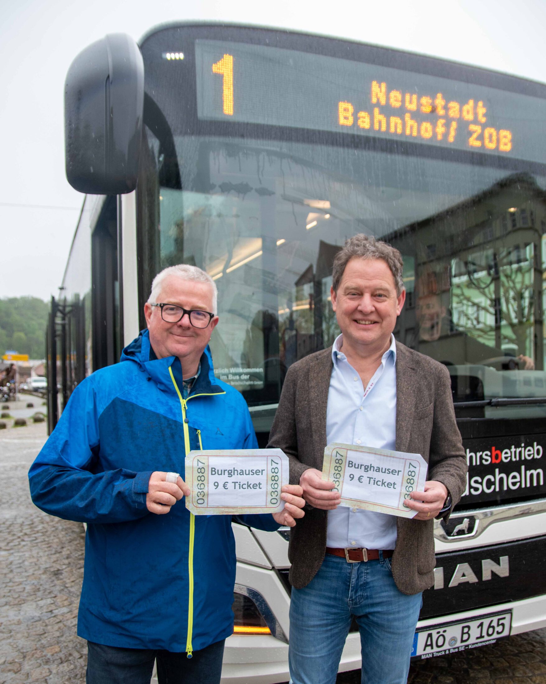Erster Bürgermeister Florian Schneider (l.) und Martin Hinterwinkler, Leiter des Ordnungsamts in Burghausen, mit symbolischen 9-Euro-Tickets am Stadtplatz. Fotocredit: Stadt Burghausen/ebh