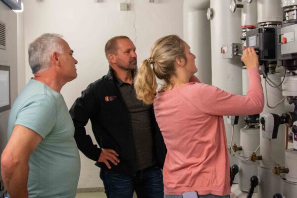 Klimaschutzmanagerin Verena Steiner mit Michael Madl (mitte) vom Gebäudemanagement und Thomas Lanner (links), Hausmeister der Franz-Xaver-Gruber-Schule, bei der Kontrolle im Heizungskeller © Stadt Burghausen/ebh