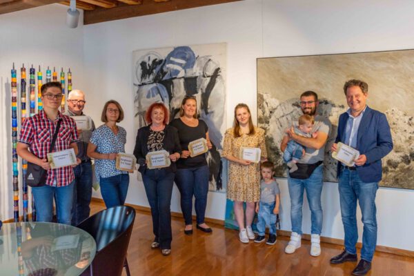 Erster Bürgermeister Florian Schneider (rechts) und Martin Hinterwinkler (zweiter von links), Leiter des Ordnungsamts, mit den Gewinnerinnen und Gewinnern der verlosten City-Bus-Tickets © Stadt Burghausen/Schick