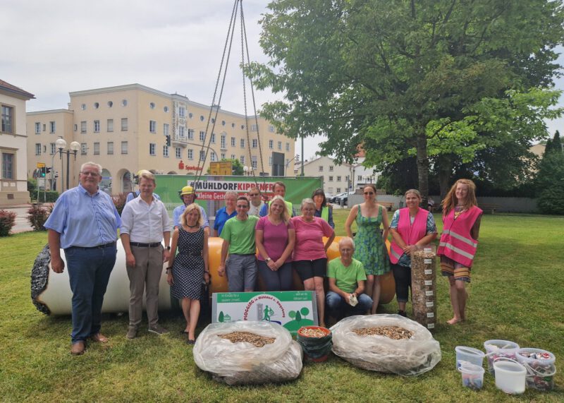 Die Riesenkippe steht nun vier Wochen am Mühldorfer Katharinenplatz vor der Einfahrt zum Stadtplatz. Vordere Reihe von links nach rechts: Zweiter Bürgermeister Norbert Stranzinger, Michael Hetzl, Erster Bürgermeister Mühldorf, Birgit Weichselgartner, Stadtbaumeisterin Mühldorf, Roland Scherer, Vorsitzender der Plogging-Gruppe Mühldorf, Sabine Scherer und Sarah Freudlsperger (dritte von rechts) mit weiteren Mitgliedern der Plogging-Gruppe.Fotocredit: Stadt Burghausen/ebh 