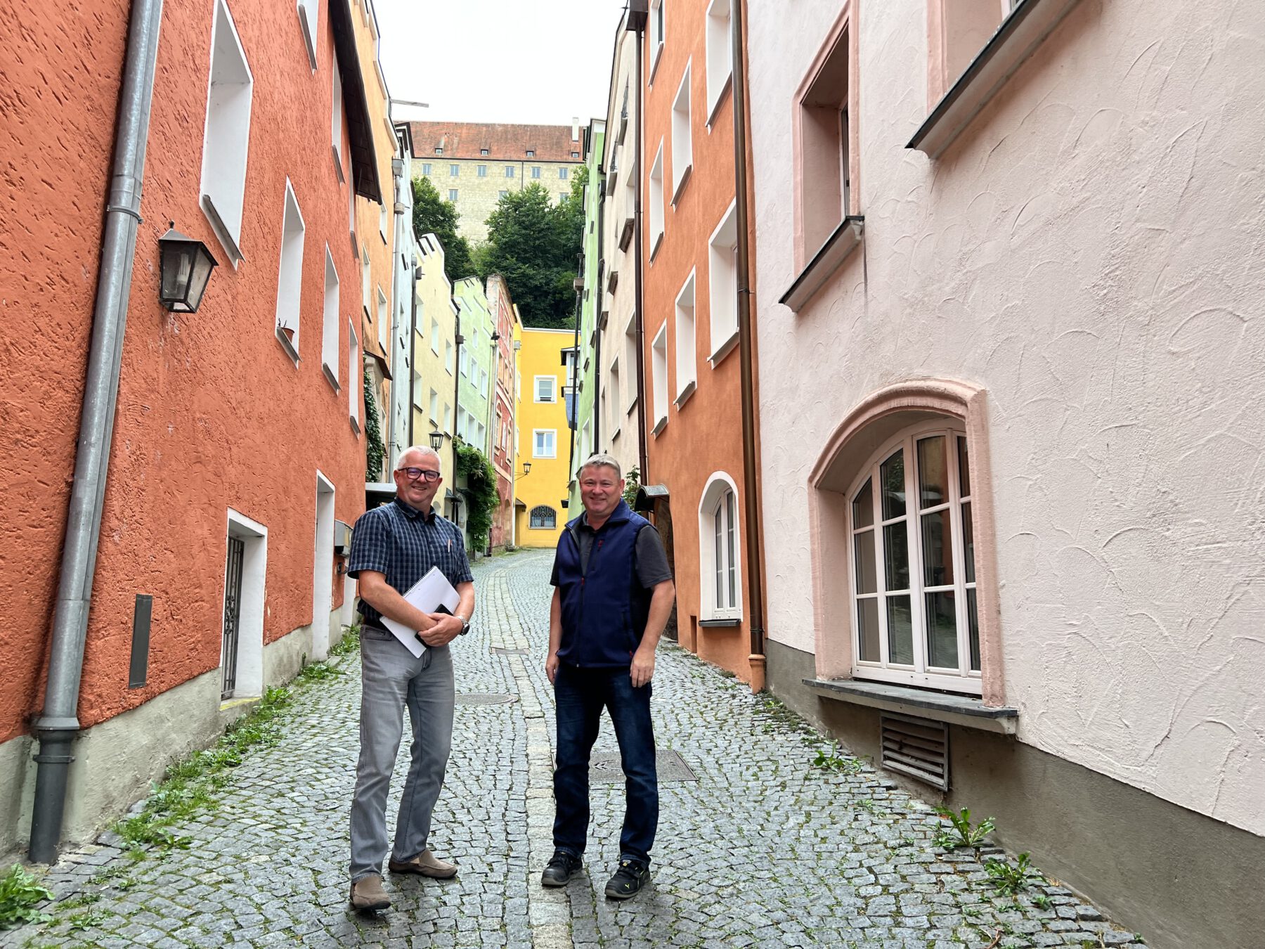 Manfred Prostmaier (rechts) und Martin Hinterwinkler beim Vor-Ort-Termin am Hofberg. Eine der engsten Straßen in Burghausen. Fotocredit: Stadt Burghausen/köx