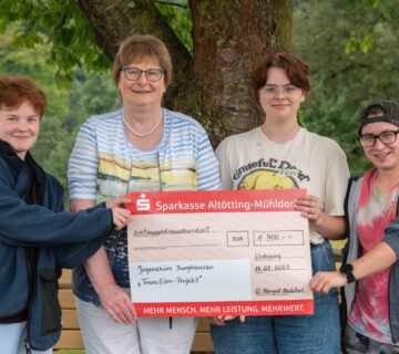 Waltraud Himpsl-Philibert übergibt Henry Burgmann (l.), Finn Winkhofer, und Laurin Karsten, drei Mitgliedern des Transfilm-Projekts, den Scheck über 1.900 Euro © Stadt Burghausen / ebh