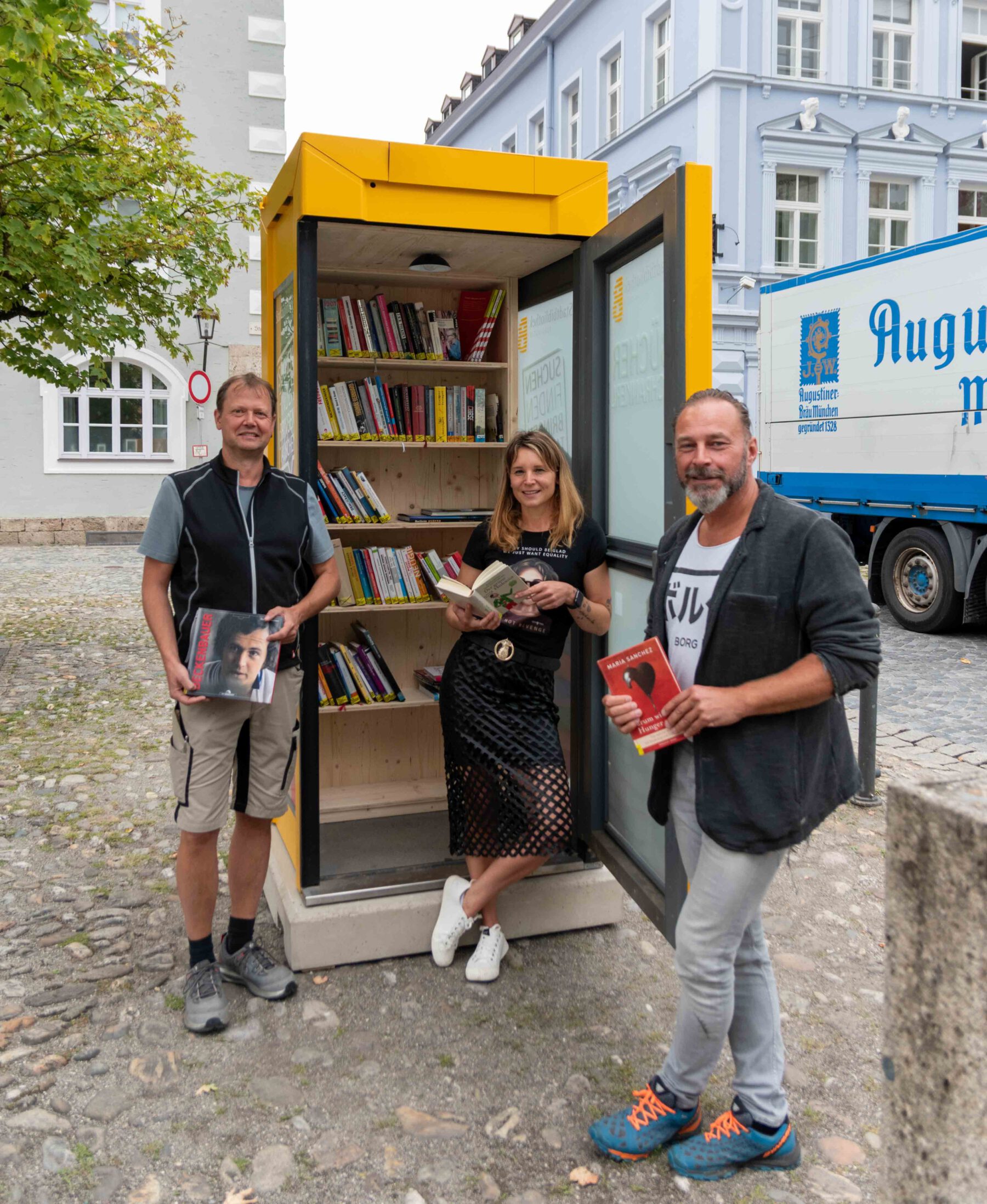 Markus Salzinger, städtischer Schreiner, Christin Moll, Leiterin der Stadtbibliothek, und Peter Schweikl, Leiter der Bauhofs, mit der Bücherzelle am Stadtplatz. © Stadt Burghausen/ebh