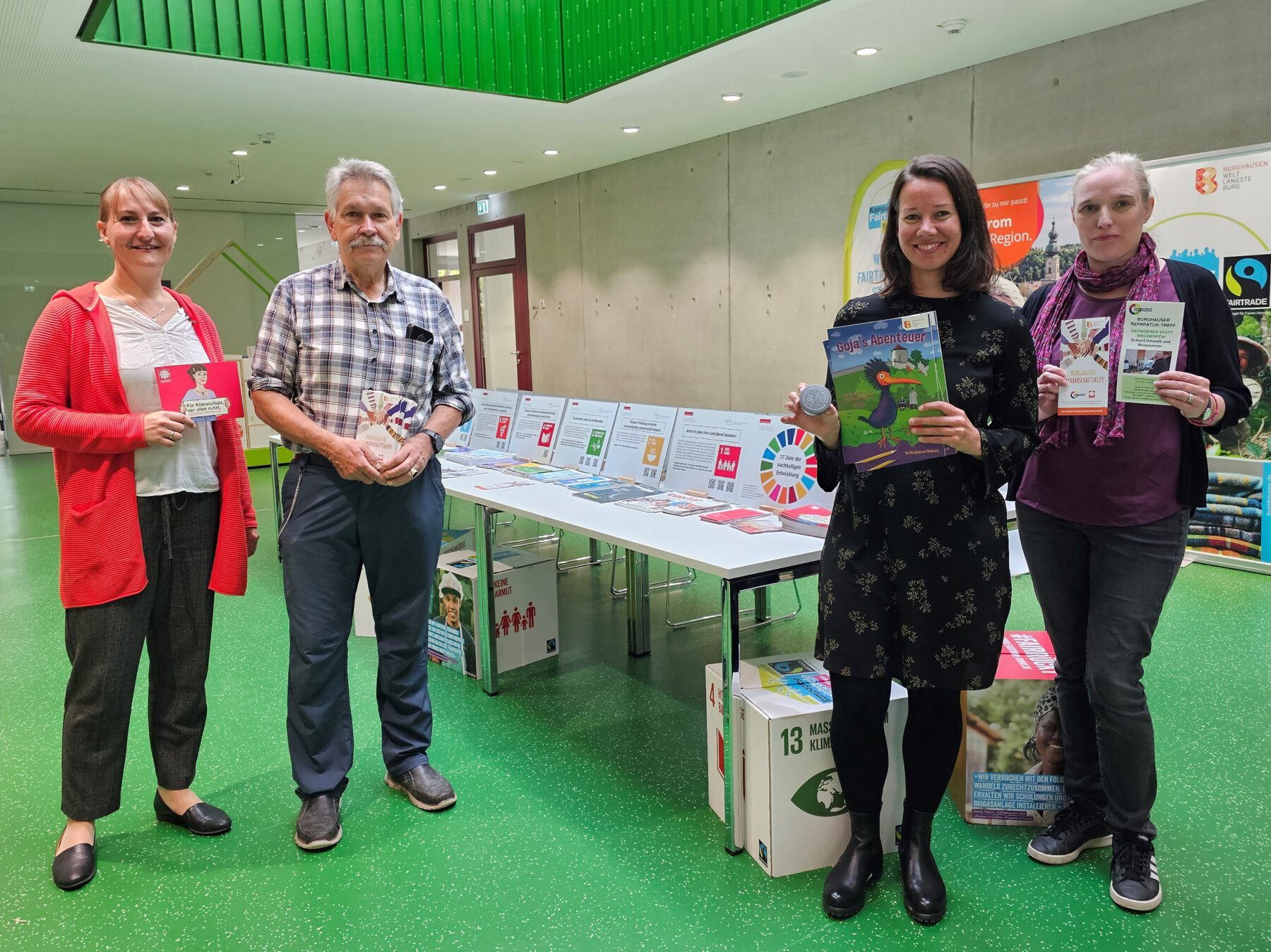Susanne Stimmer von der Gemeindecaritas Altötting, Günter Reithmeier von der Pfarrcaritas Burghausen, Christine Auberger, Leiterin des Hauses der Familie, und Elli Huster von der Bürgerinsel Burghausen, mit der Wanderausstellung über die 17 Nachhaltigkeitsziele. © Stadt Burghausen/ebh