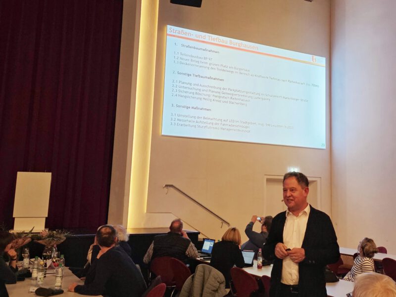 Erster Bürgermeister Florian Schneider bei der Präsentation seines Tätigkeitsberichts bei der Bürgerversammlung 2023 © Stadt Burghausen/ebh