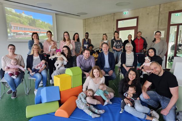 Die Eltern und Kinder, die zur Neugeborenenbegrüßung gekommen sind, mit Erstem Bürgermeister Florian Schneider (mittlere Reihe Dritter von rechts), Familienreferentin Doris Graf (mittlere Reihe Zweite von rechts), Christine Auberger (hintere Reihe Vierte von links) und Mariella Röben vom Kinderschutzbund (hintere Reihe rechts) © Stadt Burghausen/ebh