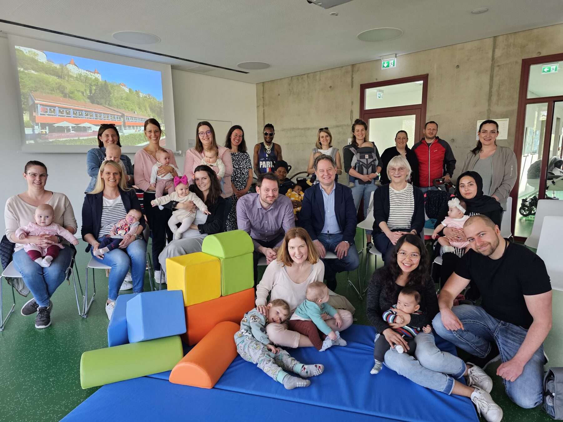 Die Eltern und Kinder, die zur Neugeborenenbegrüßung gekommen sind, mit Erstem Bürgermeister Florian Schneider (mittlere Reihe Dritter von rechts), Familienreferentin Doris Graf (mittlere Reihe Zweite von rechts), Christine Auberger (hintere Reihe Vierte von links) und Mariella Röben vom Kinderschutzbund (hintere Reihe rechts) © Stadt Burghausen/ebh