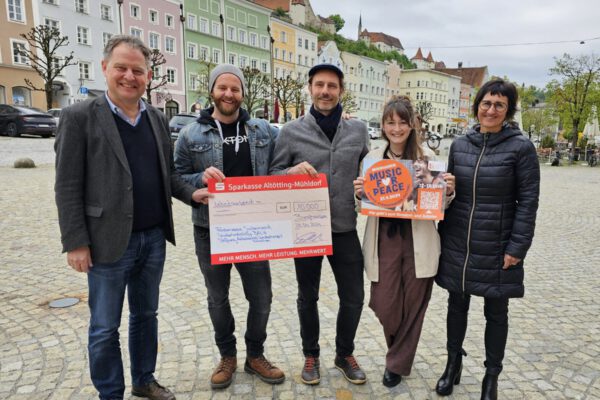 Freudig nahmen die Organisatoren des Benefiz-Straßenmusikfestivals die von der Stadt auf 10.000 € aufgestockte Spendensumme entgegen. Von links: Erster Bürgermeister Florian Schneider, die Organisatoren Max Roxton, Erik Bönisch, Susanne Kramlinger und Sigrid Resch, Geschäftsführerin der Burghauser Touristik GmbH. Fotocredit: Stadt Burghausen