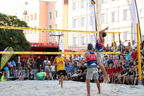 PM 106 Beach-Volleyball mit Sand aus Mü wird im Juli am Burghauser Stadtplatz gespielt Im Juli 2024 wird am Stadtplatz hochkarätiges Volleyball gespielt. Zuschauer dürfen auf Tribünen Platz nehmen und sind herzlich willkommen. Die Burghauser Gastronomie freut sich auf die Gäste. Fotocredit: Fabian Bartsch (Volleyball)