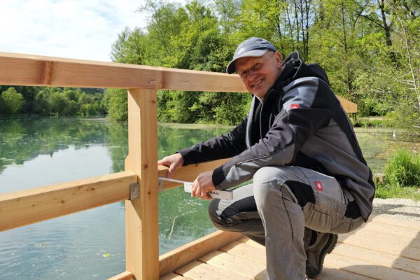 Christoph Bonauer, seit 25 Jahren städtischer Schreiner, kontrolliert, ob bei der neuen Wöhrseebrücke alles richtig verbaut wurde. Schon 1991, bei der letzten Sanierung der Brücke, war Bonauer beteiligt © Stadt Burghausen/ebh