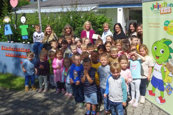 Die Kita Liebfrauen Burghausen ist Jolin-chenKids-Einrichtung. Angela Adelsperger-Birk von der AOK (Mitte.) überreichte das Türschild an Einrichtungsleiterin Esther Wallinger (4.v.re.) und an die Leiterinnen der einzelnen Gruppen mit den Burghausener Kindern