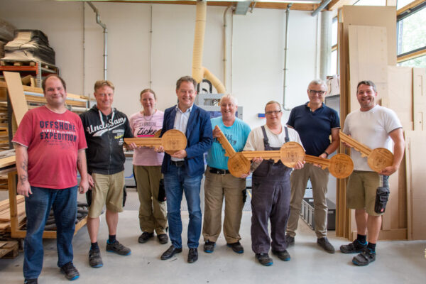 PM 158 Gruppenfoto 2 Schlüsselübergabe Rupertiwerkstätten mit Bgm Schneider Foto köx Stolze Schlüssel-Hersteller in der Schreinerei der Rupert Werkstätten Altötting: Armin Birndorfner (v.l.), Gruppenleiter Bichlmeier Christian, Kleiner Elisabeth, Erster Bürgermeister von Burghausen Schneider Florian, Freimüller Renate, Lohr Maximilian, Einrichtungsleiter Zumüller Günther sowie Gruppenleiter Meindl Andreas. Fotocredit: Stadt Burghausen/köx
