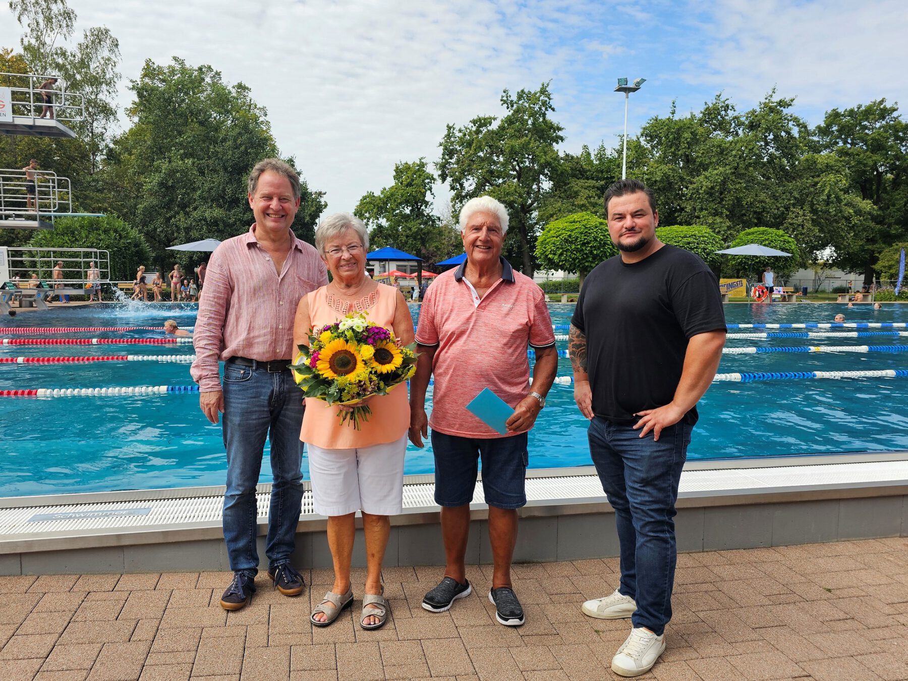 Das Ehepaar Christel und Paul Pieczka waren die 100.000 Besucher des Burghauser Freibads in der Saison 2024. Erster Bürgermeister Florian Schneider und technischer Bäderleiter Florian Moser übergaben dem Ehepaar Blumen und einen Gutschein © Stadt Burghausen/ebh
