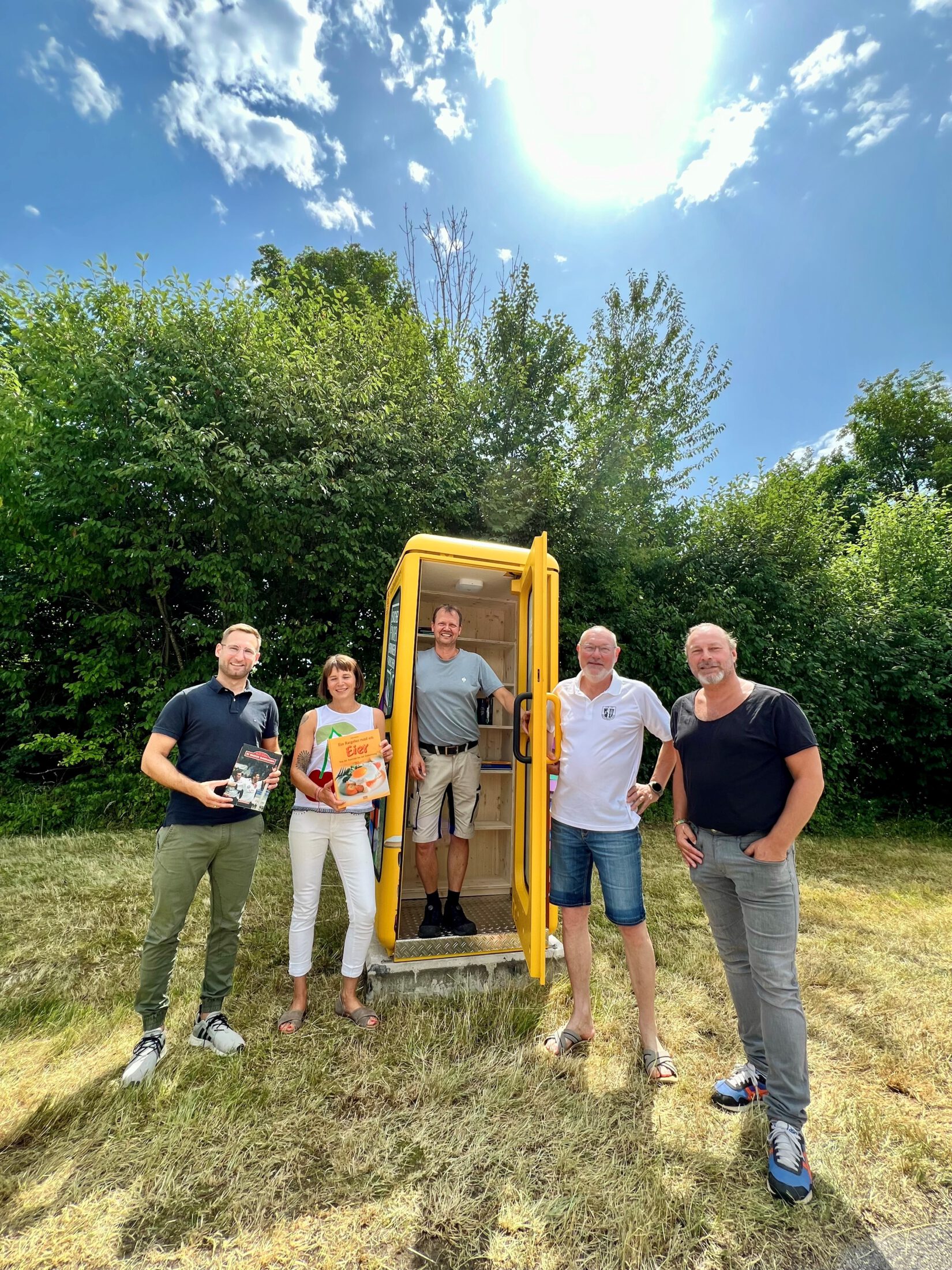 Andreas Huber vom SV Wacker e.V. (v.l.), Christian Moll als Leiterin der Stadtbibliothek, Stadt-Schreiner Markus Salzinger, Bücherzellen-Pate Robert Augenstein und Bauhofleiter Peter Schweikl bei der Bücherzelle in Scheuerhof. Fotocredit: Stadt Burghausen / Königseder