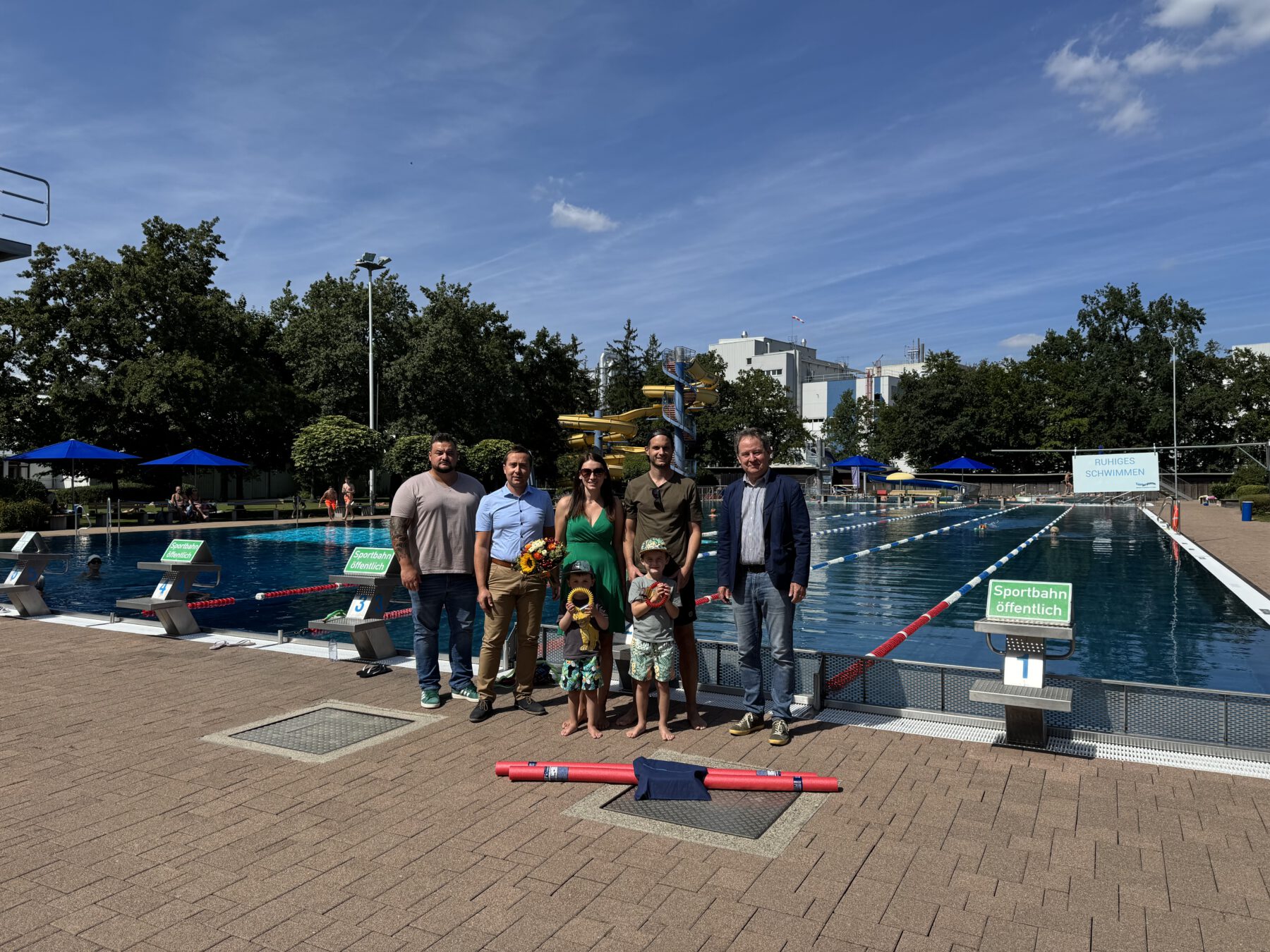 Erster Bürgermeister Florian Schneider (v.r.) begrüßte die Burghauser Familie Rene Kreil sowie Julia Resch mit den Kindern Luca und Jonas. Bäderleiter Stefan Sajdak und Florian Moser überreichten dem 100.000 Badegast einen Gutschein sowie Ringe zum Auftauchen, eine Poolnudel und für die Mama einen Blumenstrauß. © Bäder Burghausen