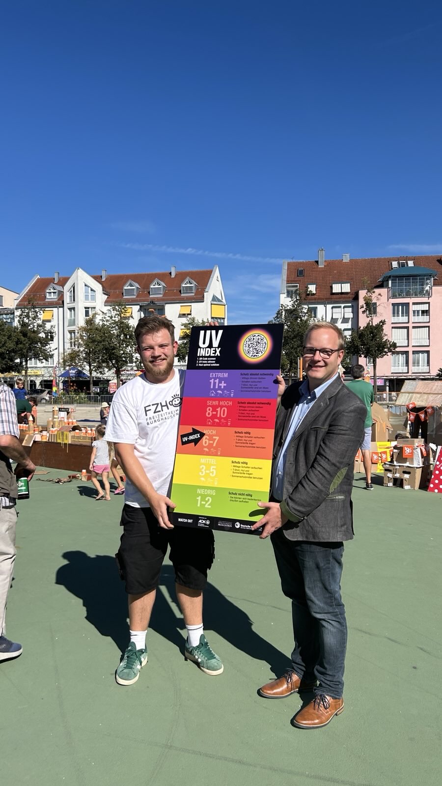 Im Rahmen der Pappstadt Burghausen nahm Marcel Anslinger (li) die UV-Index-Tafel von Thomas Gruber entgegen. © AOK