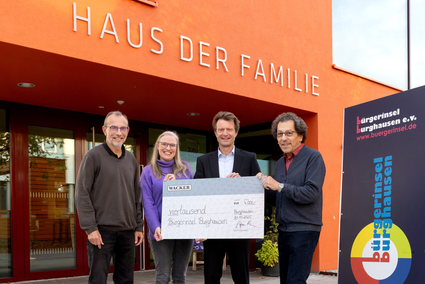 Foto (Wacker Chemie AG): Stv. WACKER-Werkleiter Stefan Henn (2.v.r.) überreicht den symbolischen Spendenscheck an Michael Schneiderhan vom Organisationsteam (1.v.l.) sowie Elli Huster (2.v.l.) und Josef Schweighofer (1.v.r.) von der Bürgerinsel Burghausen.