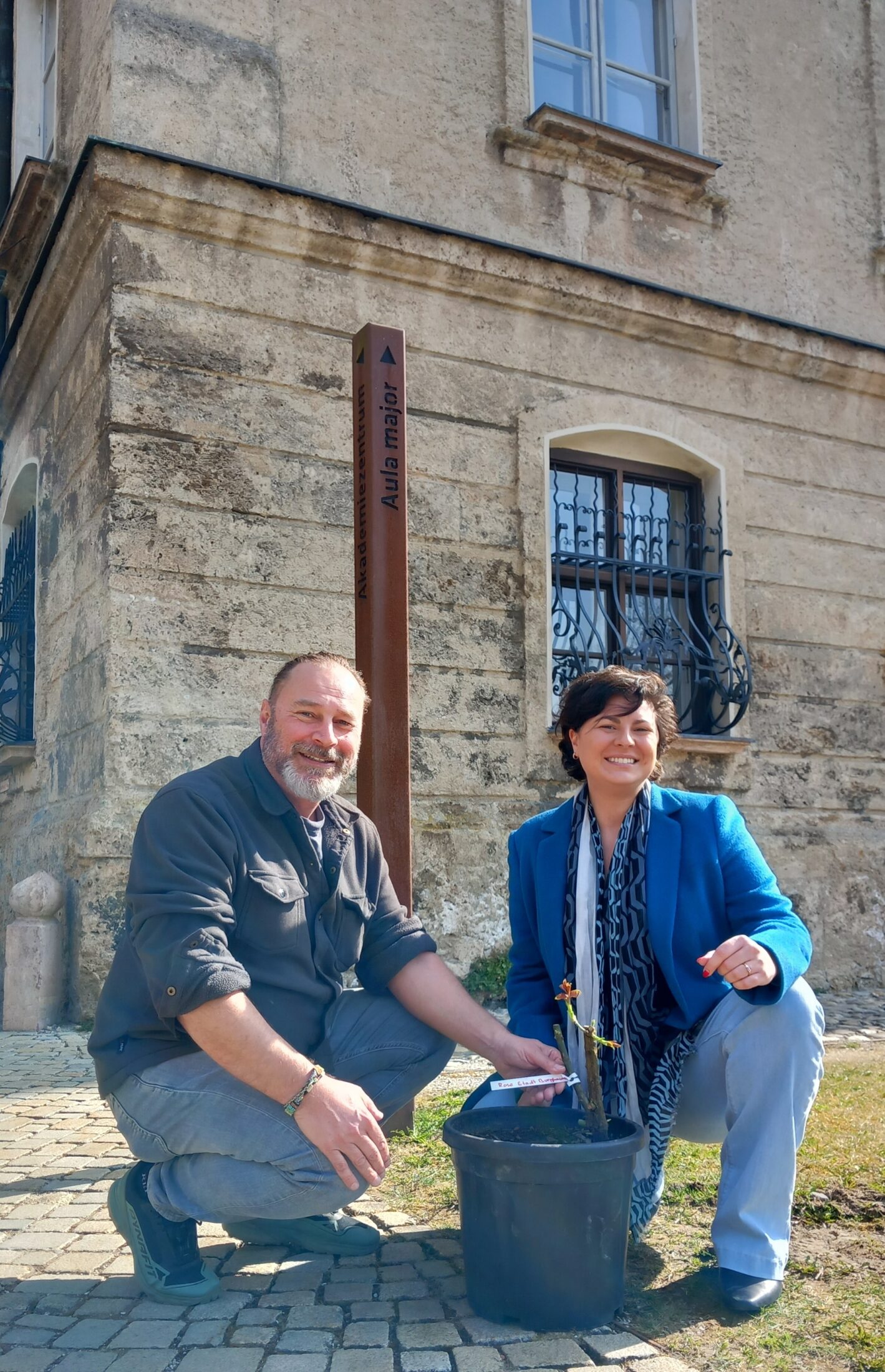 Bauhofleiter Peter Schweikl und Elina Weinmann mit einer der gespendeten Pflanzen im TUM Akademiezentrum in Raitenhaslach: Zukünftig wird der Burghauser Rosenstock im Garten der Hans Albers Villa am Starnberger See blühen  Fotocredit: Stadt Burghausen